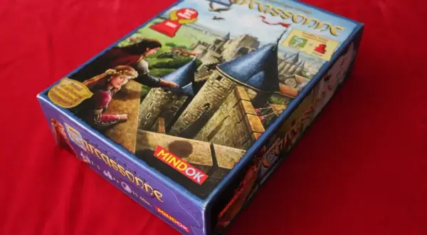 Pudełko gry planszowej Carcassonne, z motywem zamku i postaci, sugeruje nowe **carcassonne rozszerzenia**.