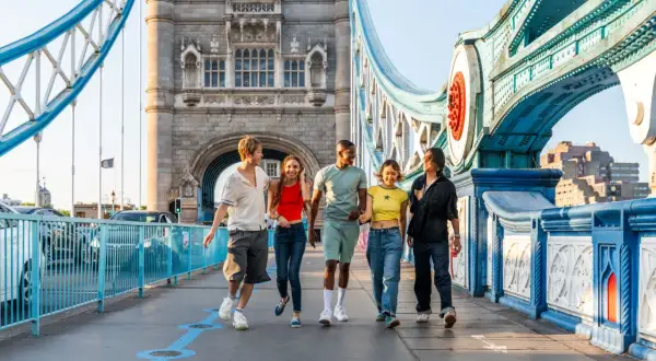 Grupa przyjaciół cieszy się londyńskim **city break** na Tower Bridge.