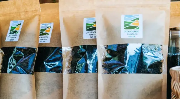 Kilka opakowań z gruzińską herbatą Plantacia. W przezroczystym okienku widać ciemne liście.