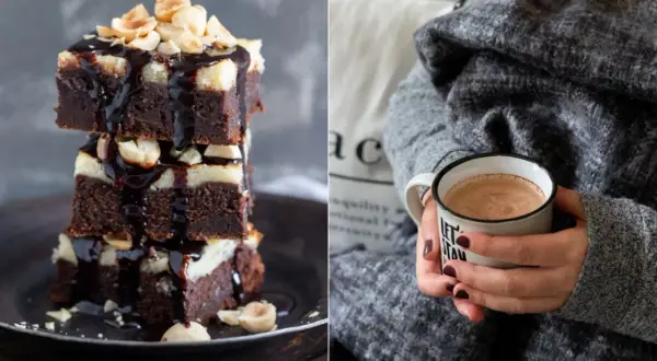 Gestapelte Cheesecake Brownies mit Schokoladenglasur und Nüssen, daneben eine Tasse Kakao.