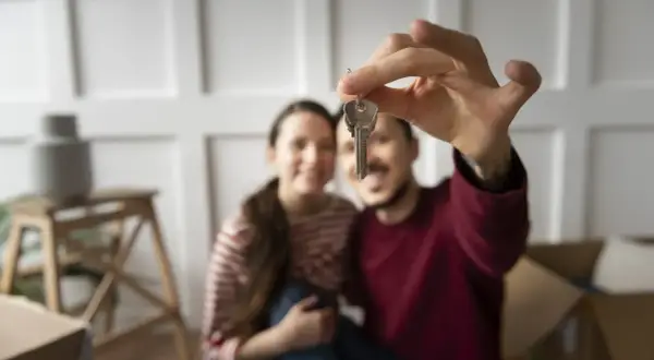 Coppia felice con le chiavi in mano, pronti per i tre passaggi per non farsi fregare quando vendi casa.