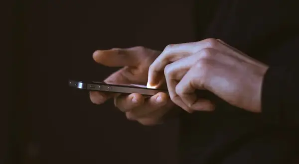 Mains utilisant un smartphone, frustrées par une application qui se ferme toute seule sur Android.