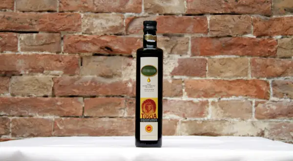 Bottiglia di olio extra vergine d'oliva D.O.P. Tuscia, il miglior olio della Tuscia, su sfondo di mattoni rossi.