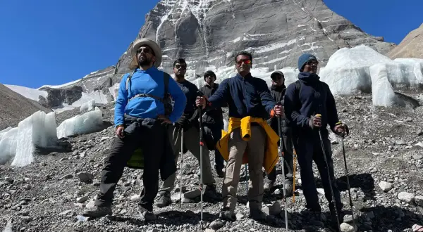 Grupa turystów z kijkami trekkingowymi na tle ośnieżonej góry. Przygotowanie do wędrówki na świętą górę Kailash w Tybecie wymaga odpowiedniego sprzętu.