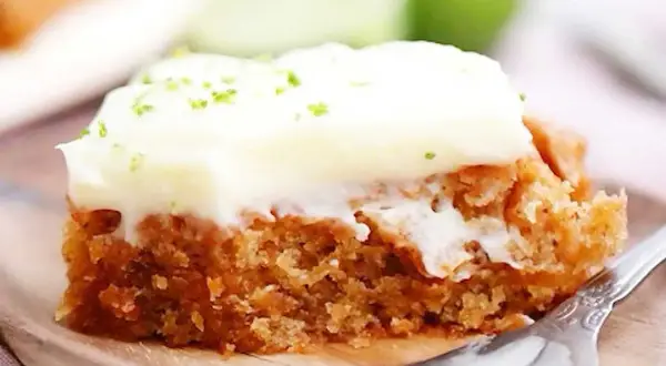 En saftig bit vegansk morotskaka med krämig frosting och rivet limeskal.