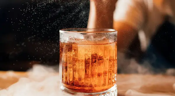 Elegancki boulevardier z lodem, otoczony mgiełką, w blasku światła.