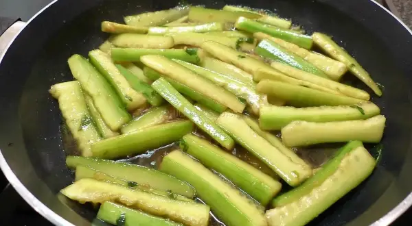 Tranches de concombre cuit dans une poêle, prêtes pour une recette savoureuse.