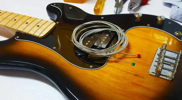 Nowe struny czekają na założenie na gitarę. Zobacz, jak łatwo to zrobić!