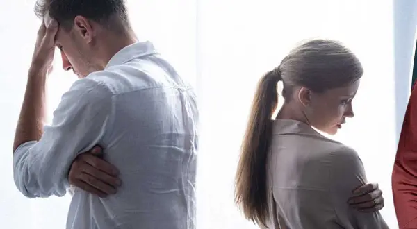 Ett par vänder ryggen åt varandra, en man med handen mot pannan, en kvinna med armarna i kors. Kanske en svår tid för anna bennich partner.