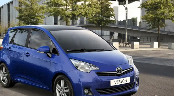 Niebieski minivan Toyota Yaris Verso z czarnym dachem, zaparkowany na zewnątrz.