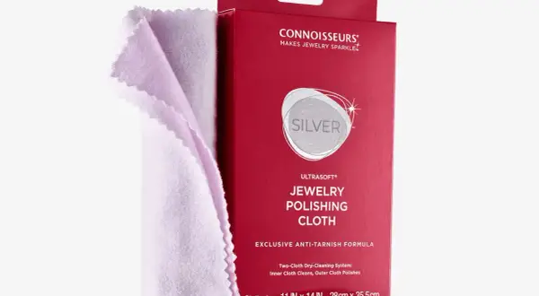 Jasnoróżowa ściereczka do polerowania srebra obok czerwonego opakowania z napisem "JEWELRY POLISHING CLOTH".