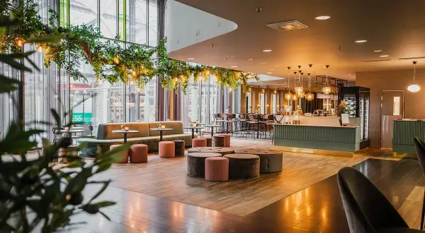 Mysig lounge med grönska och belysning, perfekt för en hotel Dorsia lunch.
