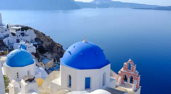 Błękitne kopuły kościołów na Santorini, idealne na wakacje. Marzysz o Santorini loty bezpośrednie?