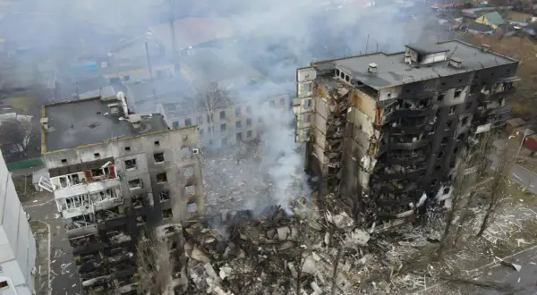 Zniszczone budynki mieszkalne, dym unoszący się nad gruzami, obraz tragedii, która rozpoczęła się, kiedy wybuchła wojna na Ukrainie.