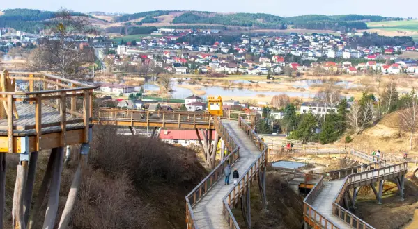 Drewniana wieża widokowa wije się wśród drzew, oferując panoramę miasteczka i jeziora.