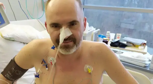 Mężczyzna w szpitalu z sondą nosową i elektrodami na klatce piersiowej. Jego walka z rakiem trzustki i rokowania są trudne, ale nie traci nadziei.