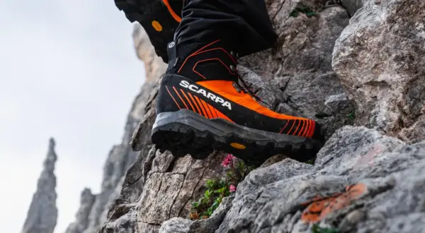 Des chaussures de randonnée Scarpa orange et noires, parfaites pour choisir son chemin sur les rochers escarpés.