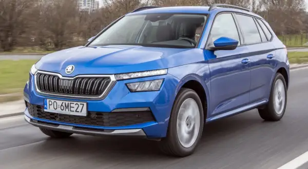 Niebieska Skoda Kamiq w ruchu drogowym. Kierowca za kierownicą. Wiele pozytywnych skoda kamiq opinie potwierdza jej walory.