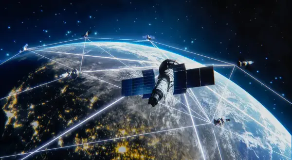 Satelity Starlink tworzą sieć połączeń wokół Ziemi, oświetlonej nocnymi światłami miast.