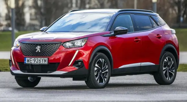 Czerwony Peugeot 2008 na zewnątrz. Wiele osób szuka peugeot 2008 opinie, by dowiedzieć się więcej o tym modelu.