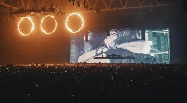 Koncert Swedish House Mafia Polska: płonące obręcze nad tłumem, na ekranie czuły uścisk.