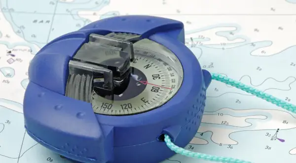 Una bussola blu su una mappa nautica, pronta per guidare l'avventura.