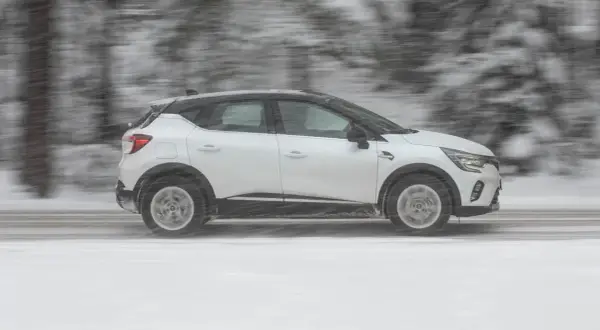 Vit Renault Captur kör i snöstorm. Kanske ett problem med väggreppet?