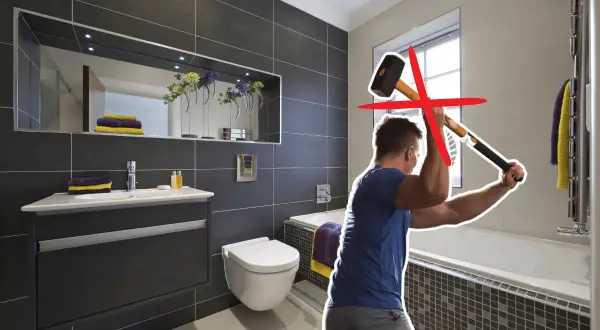 Un homme s'apprête à casser le carrelage mural de la salle de bain avec une masse. Une croix rouge indique que ce n'est pas la bonne méthode.