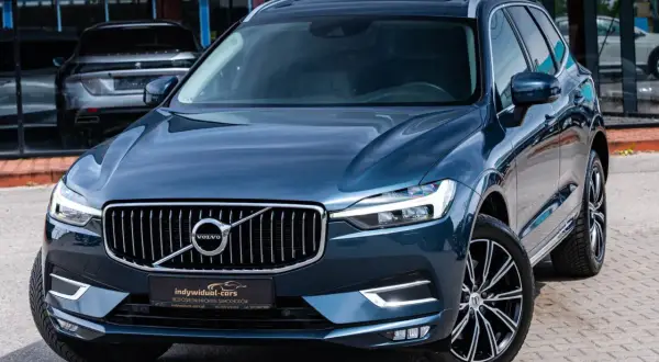 Elegancki, ciemnoniebieski SUV Volvo z chromowanym grillem. Idealny wybór dla szukających auta do 60 tys.