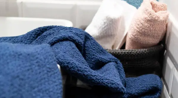 Asciugamani blu, bianchi, rosa e azzurri pronti per essere lavati a 90 gradi per una pulizia profonda.