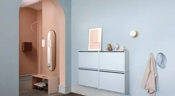Sanfter Flur mit Wand in Rosé und Hellblau. Moderne Schuhschränke und eine Bank bieten praktische Aufbewahrung. Tolle flur farbe ideen für ein einladendes Ambiente.