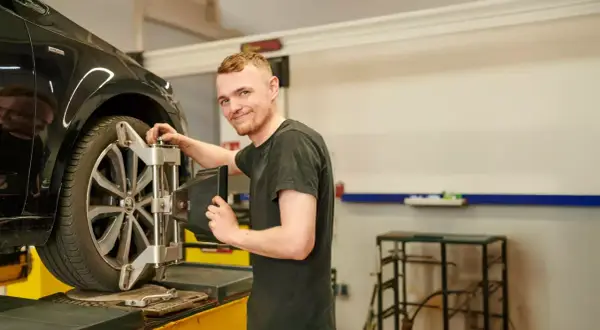 Mechaniker prüft die Spur am Auto.