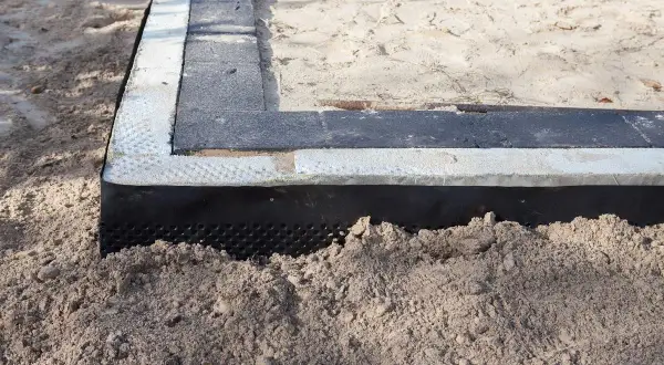 Fundament budowlany z warstwą izolacyjną. Dowiedz się, **poliuretan co to** i jak chroni budynki przed wilgocią.