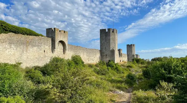 Imponerande ringmur med torn, en av de mest sevärda platserna att se i Visby. Grönskande natur längs muren.