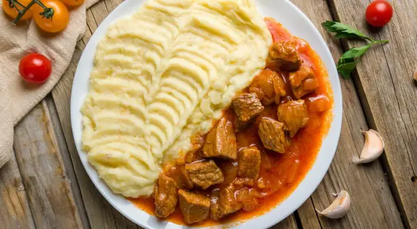 Gulasz wieprzowy z puree ziemniaczanym. Idealny na obiad, gdy zastanawiasz się, ile gotować gulasz wieprzowy, by był miękki.