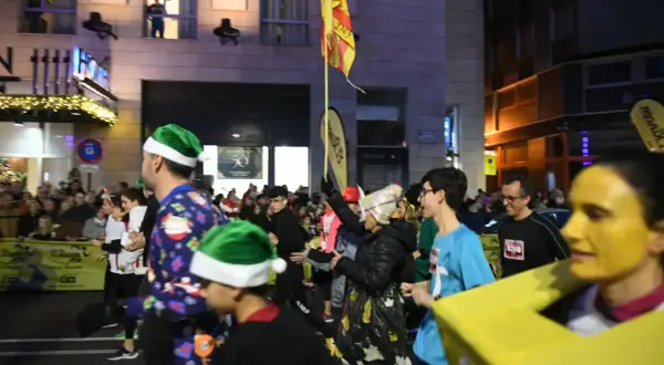 Participantes con gorros navideños y disfraces corren en el recorrido San Silvestre Zaragoza.