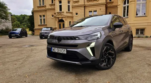 Szary Renault Symbioz przed zabytkowym budynkiem. Wiele osób szuka **Renault Symbioz opinie**, a ten model wygląda obiecująco.