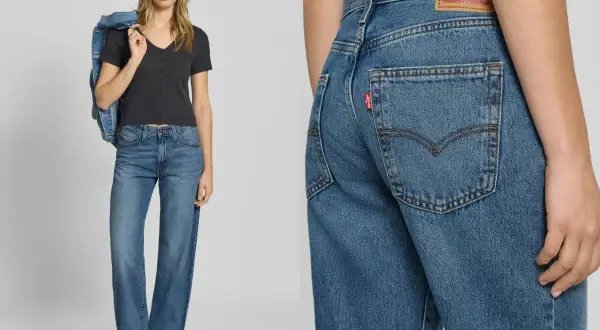 Modelka w jeansach Levi's i czarnej bluzce, z kurtką dżinsową na ramieniu. Detal zbliżenia na tył spodni z charakterystyczną czerwoną metką.