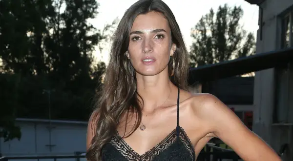 Kamila Szczawińska w czarnej, koronkowej sukience z cienkimi ramiączkami, z dużymi kolczykami i delikatnym naszyjnikiem.