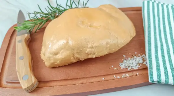 Un trozo de foie gras sobre tabla de madera, con romero, sal y un paño a rayas. La diferencia entre foie y foie gras es la preparación.