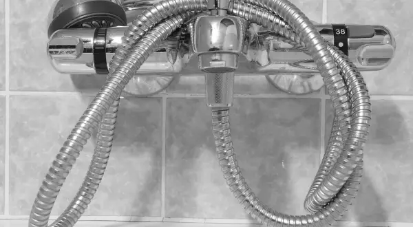 Chrom-Duscharmatur mit Schlauch und Handbrause, bereit zum duscharmatur wechseln. Die Temperaturanzeige zeigt 38 Grad.