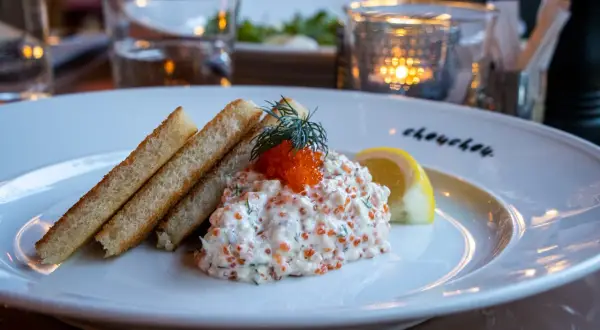 En läcker vegetarisk toast Skagen med rostat bröd, krämig röra med dill och rom, toppad med en dillkvist och citronklyfta.