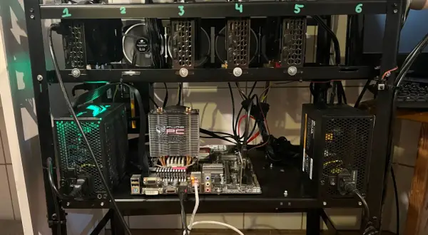 Rig do kopania kryptowaluty z sześcioma kartami graficznymi, płytą główną i zasilaczami.
