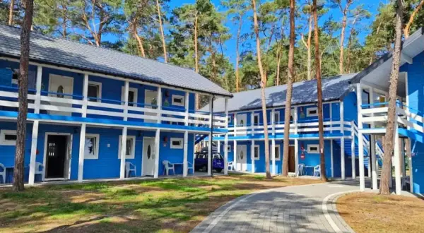 Niebieskie domki letniskowe w lesie, idealne na dziwnów noclegi blisko morza. Dostępne pokoje na parterze i piętrze z balkonami.