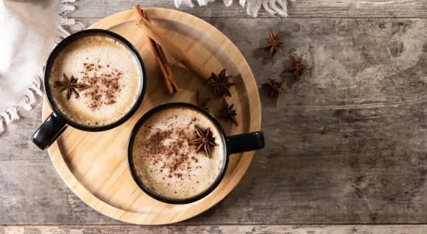 Deux tasses de latte épicé, garnies d'anis étoilé et de cannelle, parfaites pour une recette latte réconfortante.