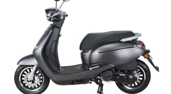 Moto gris, estilo clásico, parecida a la Vespa, con asiento negro y detalles cromados.