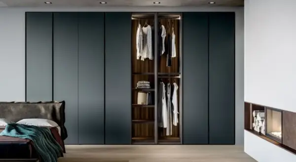 Armadio a muro con ante scorrevoli, che mostra l'interno con abiti appesi e ripiani. Le dimensioni armadio camera da letto sono perfette per un look moderno.