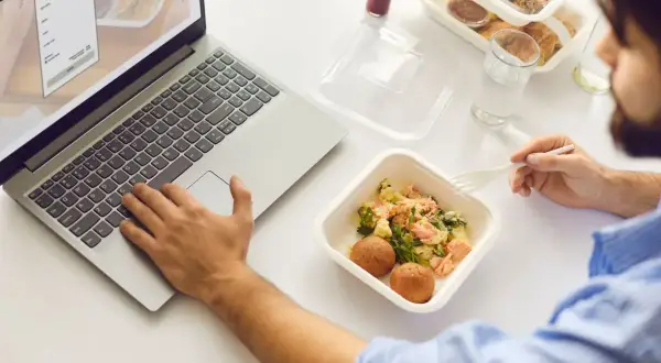 Praca przy laptopie i posiłek z cateringu. Zastanawiasz się nad usługą cateringową a odliczeniem VAT?