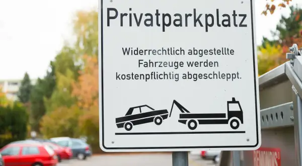 Schild "Privatparkplatz": Widerrechtlich abgestellte Fahrzeuge werden kostenpflichtig abgeschleppt. Wer zahlt den Abschleppdienst? Der Falschparker!
