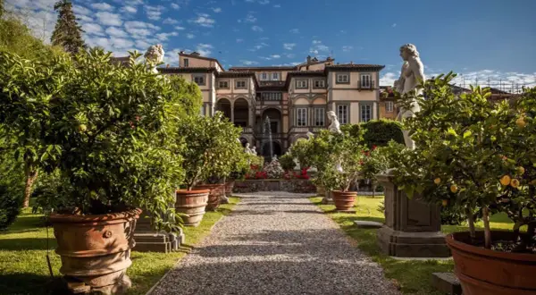 Palazzo Pfanner et son jardin à Lucca, avec des arbres en pot, des statues et une fontaine.